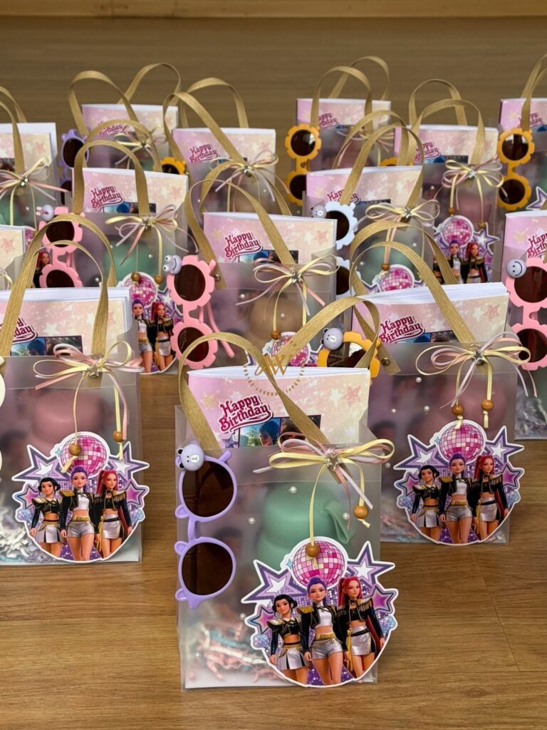 Clear plastic birthday party favor bags filled with sunglasses and pop star cutouts.