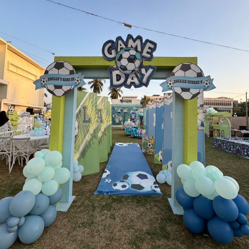 Soccer themed party entrance with game day sign, blue balloons, and soccer runner.