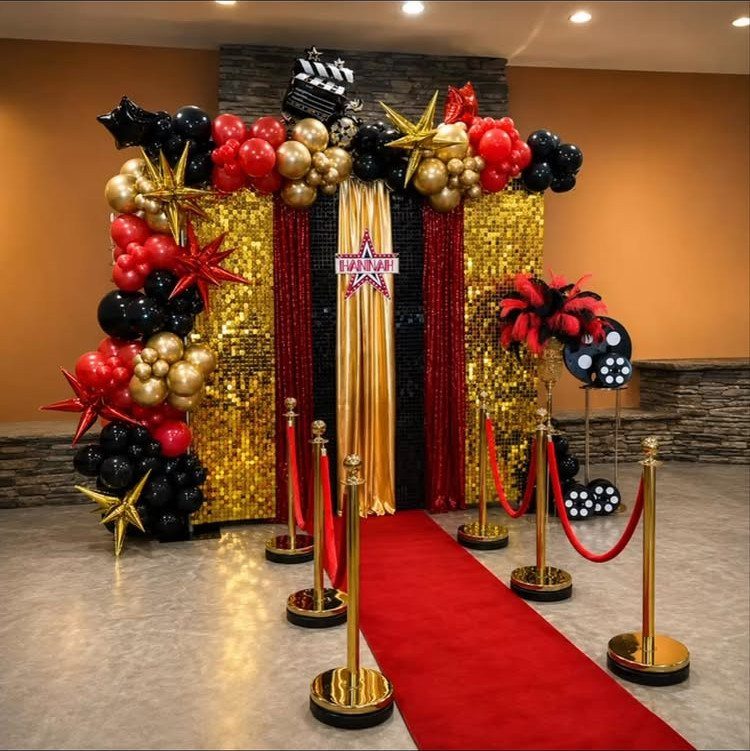 Red carpet entrance with gold sequin backdrop and red, gold, and black balloons.