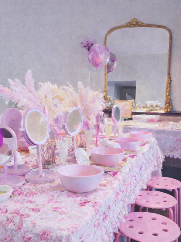Pink pampering station with bowls, mirrors, and floral decor for a spa day.