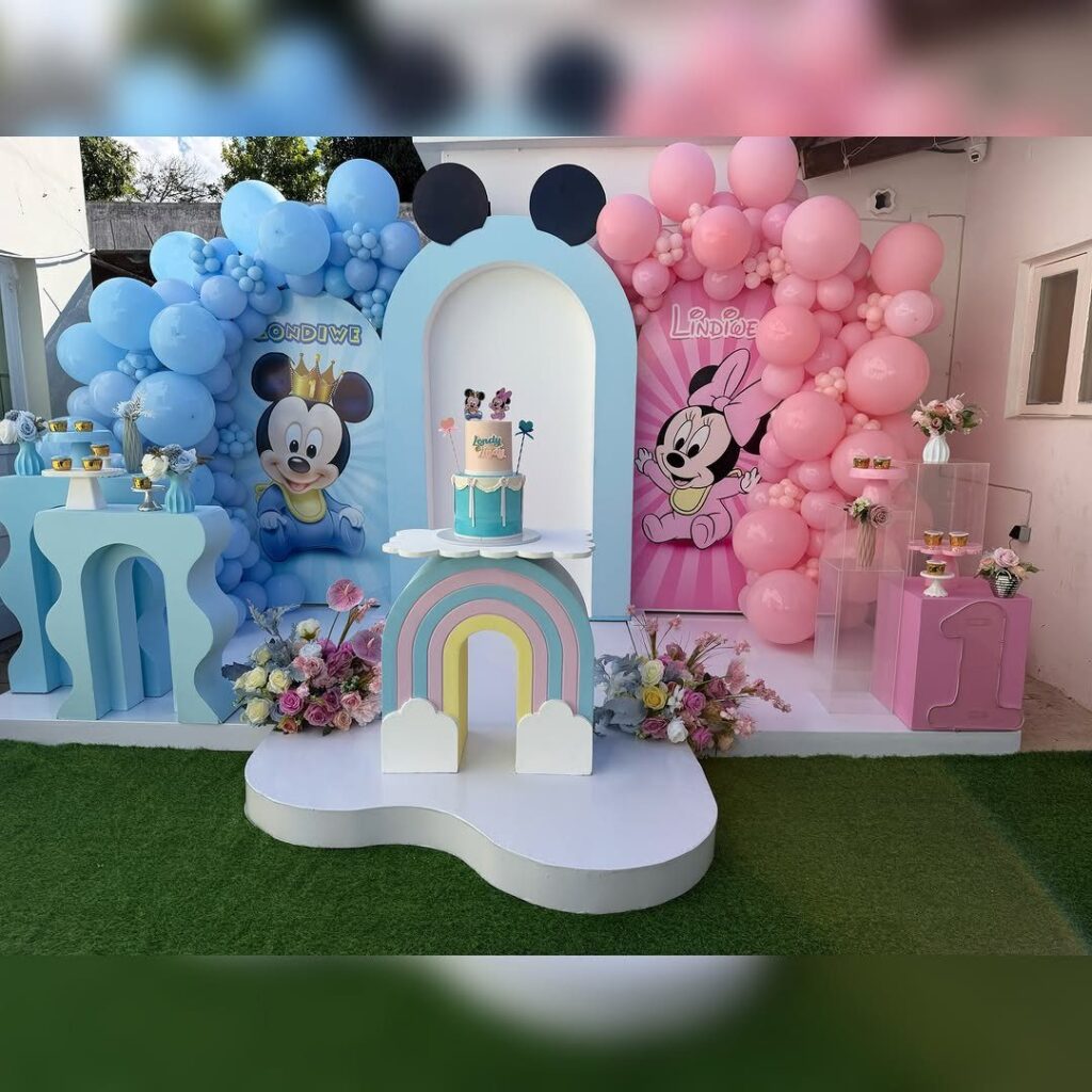 Mickey and Minnie Mouse birthday party decorations with pink and blue balloons.